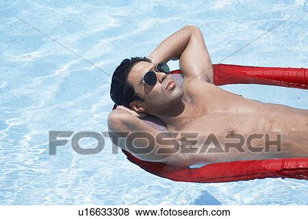Young man lying on pool raft View Large Photo Image Stock Photo - Young man lying on pool raft. Fotosearch