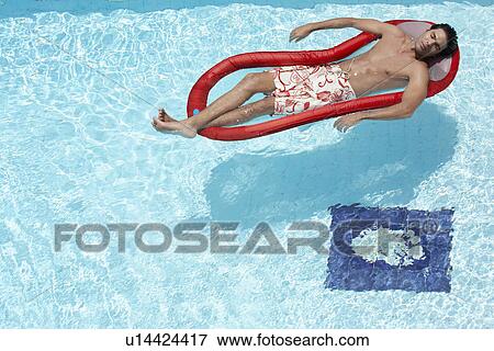 Young man sleeping on inflatable mattress in swimming pool View Large Photo Image Stock Photo - Young man sleeping on inflatable mattress in swimming pool. Fotosearch
