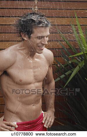 Young man taking shower outdoors View Large Photo Image Stock Image - Young man taking shower outdoors. Fotosearch