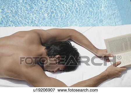 Young man with book sleeping by pool View Large Photo Image Stock Photo - Young man with book sleeping by pool. Fotosearch