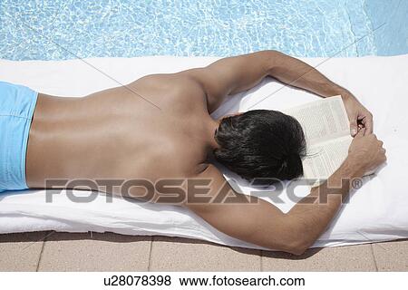 Young man with book sleeping by pool View Large Photo Image Stock Photo - Young man with book sleeping by pool. Fotosearch