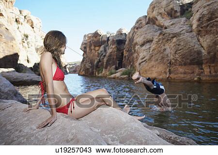 Young woman looking at boyfriend diving View Large Photo Image Stock Image - Young woman looking at boyfriend diving. Fotosearch