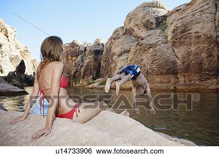 Young woman looking at boyfriend diving View Large Photo Image Stock Photograph - Young woman looking at boyfriend diving. Fotosearch