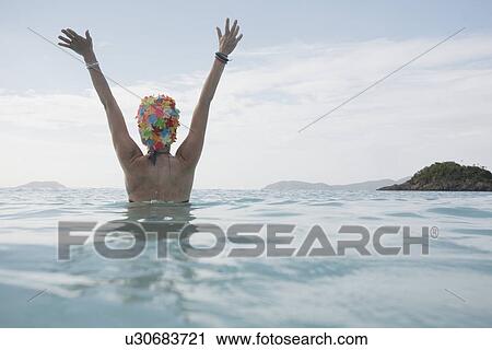Young woman raising hands in ocean at dusk, St John, US Virgin Islands, USA View Large Photo Image Stock Image - Young woman raising hands in ocean at dusk, St John, US Virgin Islands, USA. Fotosearch