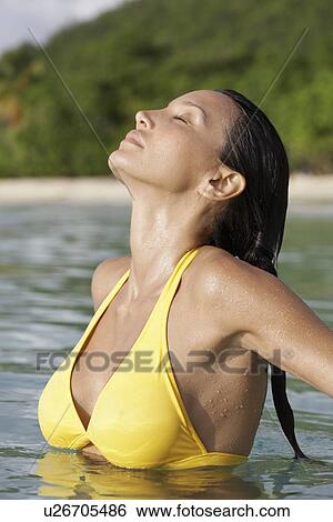 Young woman standing deep in water with eyes closed View Large Photo Image Stock Photograph - Young woman standing deep in water with eyes closed. Fotosearch