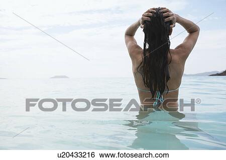 Young woman standing in water, St. John, US Virgin Islands, USA View Large Photo Image Stock Photograph - Young woman standing in water, St. John, US Virgin Islands, USA. Fotosearch