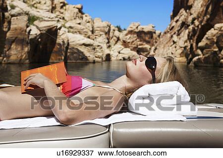 Young woman with book relaxing on motorboat View Large Photo Image Stock Photo - Young woman with book relaxing on motorboat. Fotosearch
