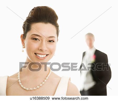Stock Photo - Bride in foreground and groom in background. Fotosearch