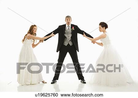 Stock Image - Brides pulling on groom's arms. Fotosearch