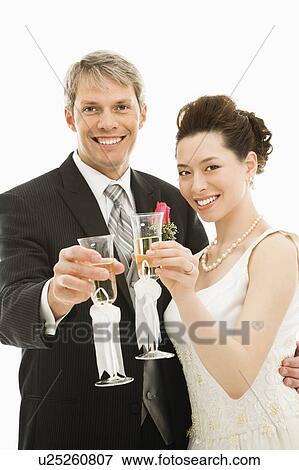 Caucasian groom and Asian bride toasting with champagne glasses. View Large Photo Image Stock Photo - Caucasian groom and Asian bride toasting with champagne glasses.. Fotosearch