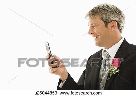 Stock Image - Caucasian groom using his cellphone.. Fotosearch