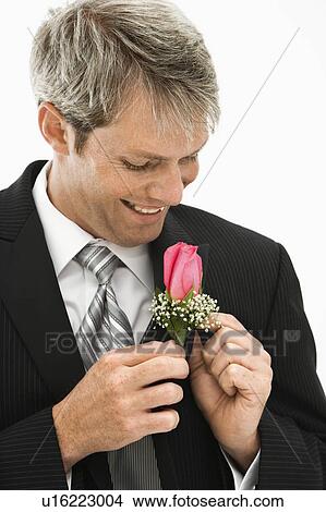 Picture - Groom adjusting boutonniere. Fotosearch