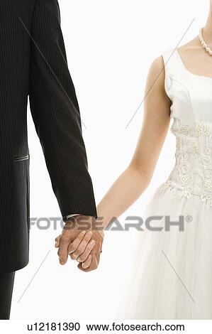Stock Image - Groom and bride holding hands. Fotosearch