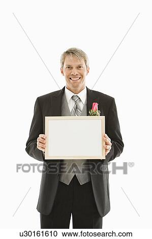 Stock Image - Groom holding blank white sign. Fotosearch