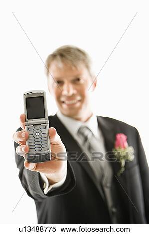 Stock Photography - Groom holding out his cellphone . Fotosearch