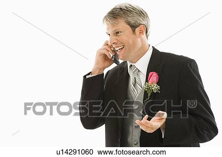 Stock Image - Groom talking on cellphone. Fotosearch