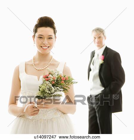 Portrait of Asian bride in foreground and Caucasian groom in background. View Large Photo Image Stock Photo - Portrait of Asian bride in foreground and Caucasian groom in background.. Fotosearch