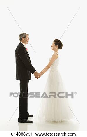 Portrait of Caucasian groom and Asian bride holding hands. View Large Photo Image Stock Image - Portrait of Caucasian groom and Asian bride holding hands.. Fotosearch