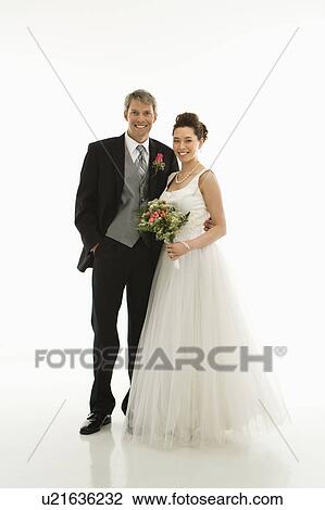 Stock Image - Portrait of Caucasian groom and Asian bride.. Fotosearch