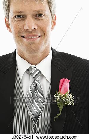 Stock Image - Portrait of Caucasian male in tuxedo with boutonniere.. Fotosearch