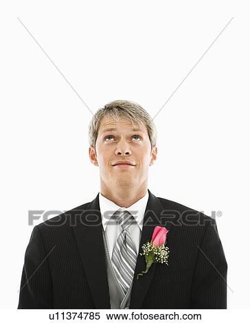 Stock Photography - Portrait of Caucasian male in tuxedo with boutonniere looking up.. Fotosearch