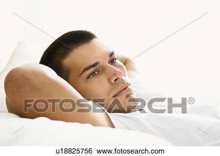 Man lying with hands behind head View Large Photo Image Stock Photograph - Man lying with hands behind head. Fotosearch