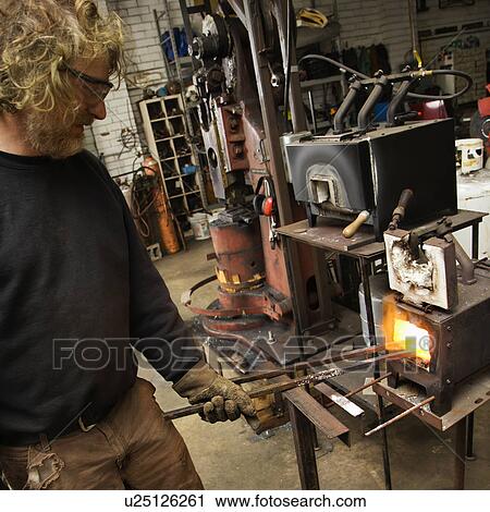 Metal-smith heating metal in forge View Large Photo Image Stock Image - Metal-smith heating metal in forge. Fotosearch