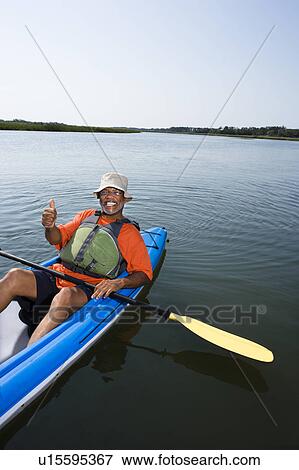 Middle-aged man in kayak, smiling and giving thumbs up gesture View Large Photo Image Stock Photo - Middle-aged man in kayak, smiling and giving thumbs up gesture. Fotosearch
