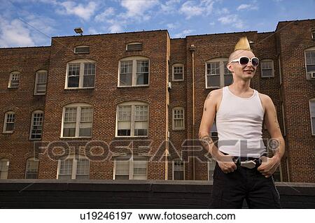 Portrait of a male punk standing in front of a building View Large Photo Image Stock Photo - Portrait of a male punk standing in front of a building. Fotosearch