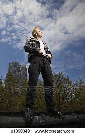 Portrait of male punk standing on ledge with skyline in background View Large Photo Image Stock Image - Portrait of male punk standing on ledge with skyline in background. Fotosearch