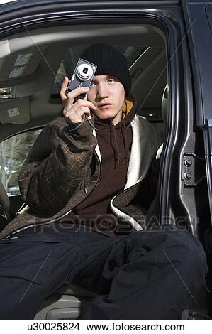 Teen taking a picture from his car. View Large Photo Image Picture - Teen taking a picture from his car.. Fotosearch