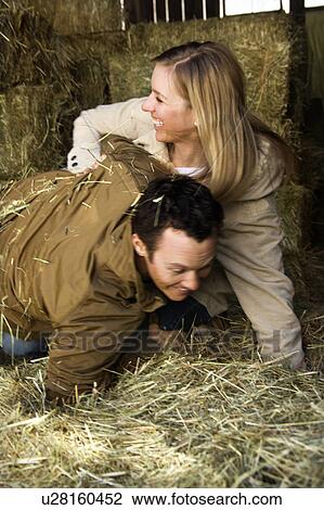 Stock Image - Couple playing in hay. Fotosearch