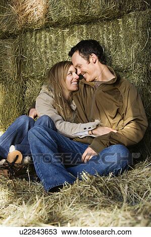 couple sitting on hay hugging and smiling at each other. View Large Photo Image Stock Image - couple sitting on hay hugging and smiling at each other.. Fotosearch