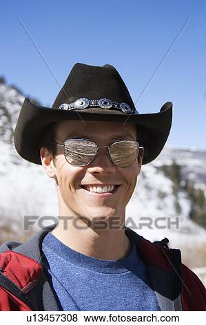 Stock Photo - Male wearing sunglasses and cowboy hat. Fotosearch