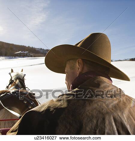Stock Photo - Man holding reins of draft horse in winter. Fotosearch