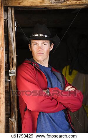 Man wearing cowboy hat with arms crossed View Large Photo Image Stock Photo - Man wearing cowboy hat with arms crossed . Fotosearch