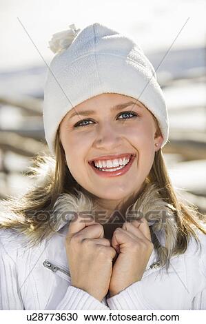 Stock Image - Portrait of a mid-adult female holding fur collar.. Fotosearch