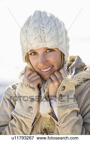 Woman in winter attire holding collar and smiling at viewer. View Large Photo Image Stock Photo - Woman in winter attire holding collar and smiling at viewer.. Fotosearch