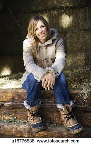 Stock Photo - Woman sitting in barn . Fotosearch