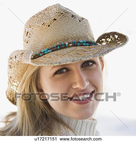 Stock Image - Young adult woman wearing cowboy hat smiling at viewer.. Fotosearch
