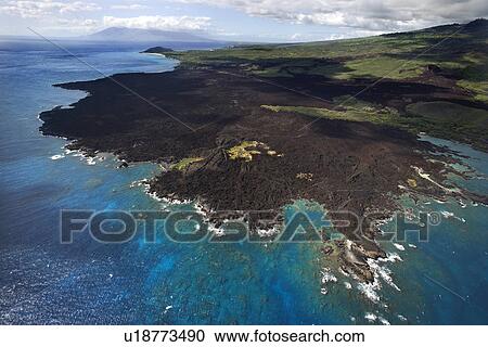 Stock Image - Aerial of Pacific ocean and Maui, Hawaii coast with lava rocks.. Fotosearch