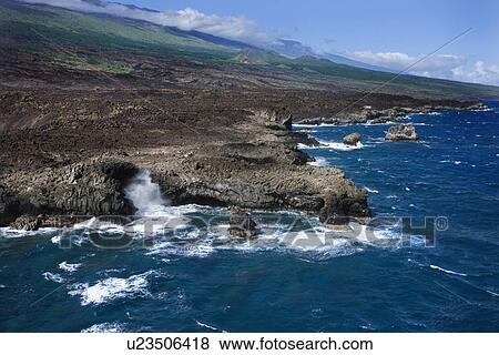 Stock Photo - Aerial of Pacific ocean and Maui, Hawaii coast with waves hitting lava rocks. Fotosearch