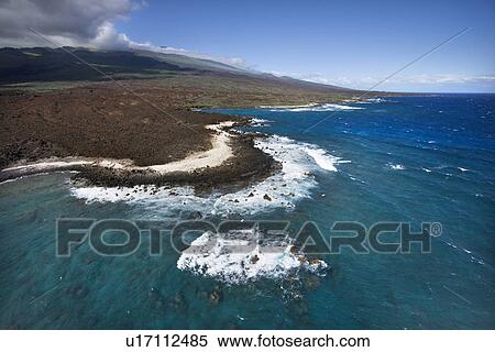 Stock Photography - Aerial of Pacific ocean and Maui, Hawaii coast with lava rocks.. Fotosearch