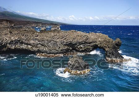 Stock Photography - Aerial of Pacific ocean and Maui, Hawaii coast with lava rocks.. Fotosearch