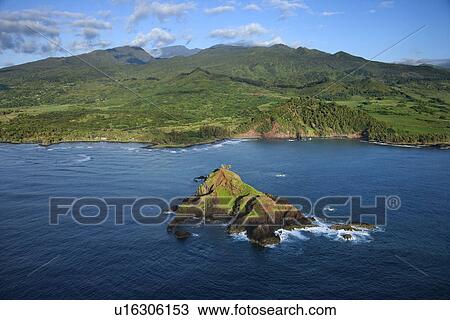 Aerial of rock jutting out of Pacific ocean off the coast of Maui, Hawaii with mountain landscape in background View Large Photo Image Stock Image - Aerial of rock jutting out of Pacific ocean off the coast of Maui, Hawaii with mountain landscape in background. Fotosearch