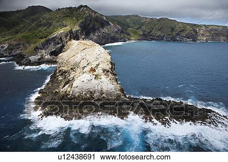 Stock Image - Aerial view of mountains and rocky Maui, Hawaii coastline. Fotosearch