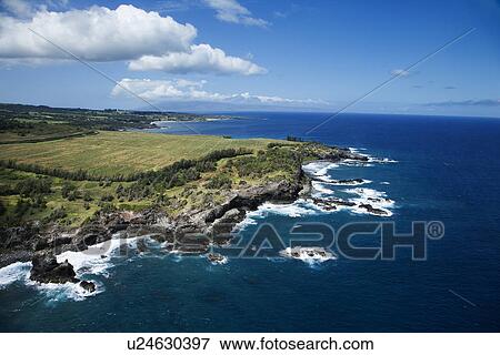 Stock Photo - Aerial view of rocky Maui, Hawaii coastline with crop fields.. Fotosearch