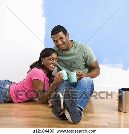 African American couple relaxing together with coffee next to half-painted wall. View Large Photo Image Stock Image - African American couple relaxing together with coffee next to half-painted wall.. Fotosearch