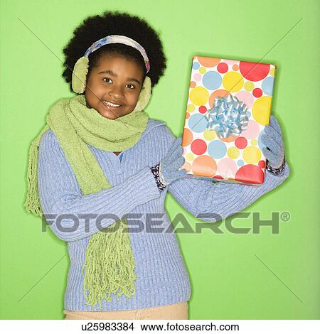 African American girl in winter clothing holding wrapped package. View Large Photo Image Picture - African American girl in winter clothing holding wrapped package.. Fotosearch