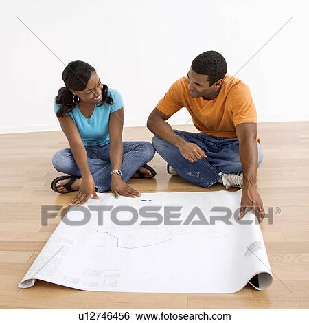 African American male and female couple sitting on floor looking at architectural blueprints. View Large Photo Image Stock Photograph - African American male and female couple sitting on floor looking at architectural blueprints.. Fotosearch